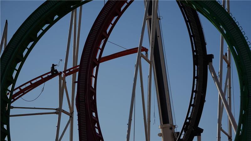 Eine Höhenkletterin nimmt bei den Aufbauarbeiten eine Schiene der Achterbahn auf dem Heiligengeistfeld in Hamburg entgegen. Der Aufbau für den Frühlingsdom hat begonnen. 