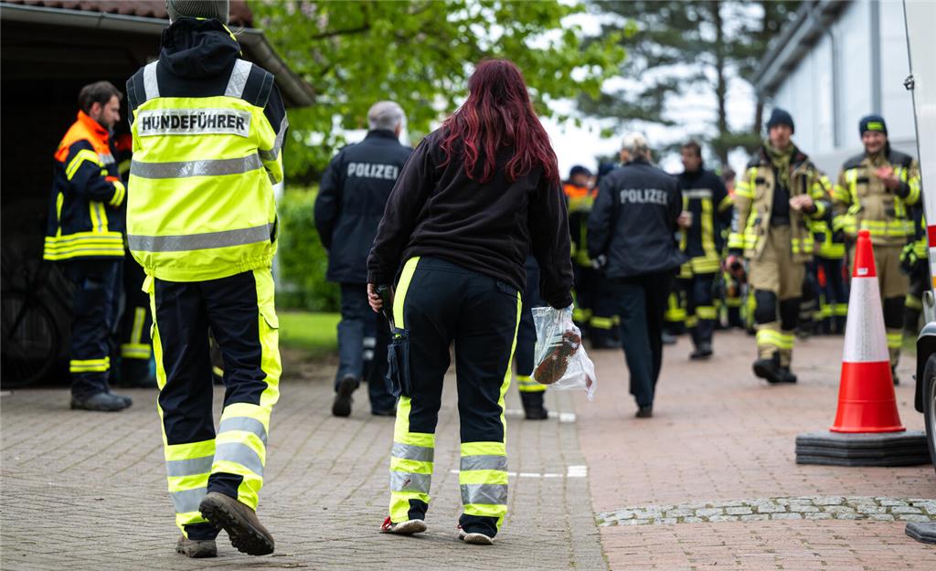 Eine Hundeführerin hält einen Beutel mit Kinderschuhen in der Hand. 
