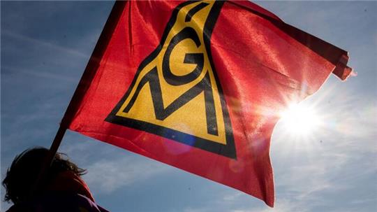 Eine IG-Metall-Fahne weht im Wind.