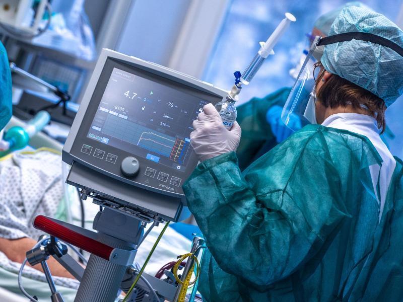 Eine Intensivschwester betreut einen Patienten in einem der Behandlungszimmer der Intensivstation in der Universitätsmedizin Rostock. (Archivbild). Foto: Jens Büttner/dpa-Zentralbild/dpa
