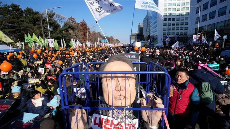 Südkoreas Parlament stimmt für Amtsenthebung des Präsidenten Eine Karikatur eines inhaftierten südkoreanischen Präsidenten Yoon Suk Yeol wird vor einer Kundgebung zur Forderung seiner Amtsenthebung vor der Nationalversammlung gezeigt. Ein zweiter Amtsenthebungsantrag gegen Yoon hat die benötigte Zweidrittelmehrheit in der Nationalversammlung erreicht.