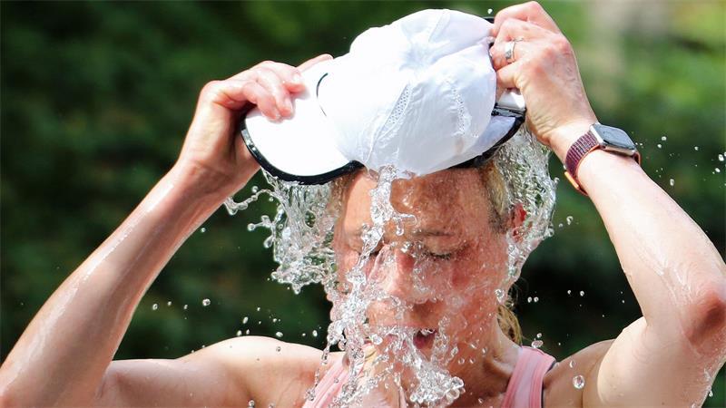 Eine Läuferin beim Hamburger Halbmarathon erfrischt sich an einer Wasserstelle. (Symbolbild)