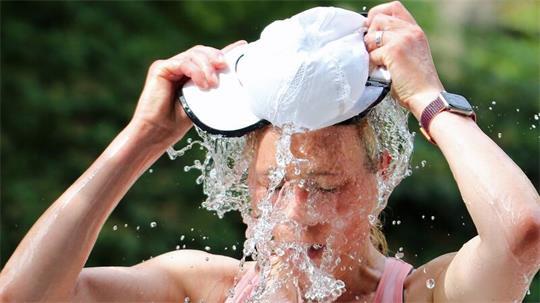 Eine Läuferin beim Hamburger Halbmarathon erfrischt sich an einer Wasserstelle. (Symbolbild)