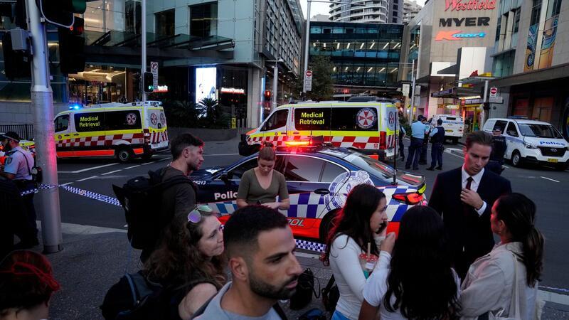 Eine Menschenmenge versammelt sich vor dem Westfield Shopping Centre. Medienberichten zufolge wurden in dem Einkaufszentrum in Sydney mehrere Menschen niedergestochen und eine Person von der Polizei erschossen.