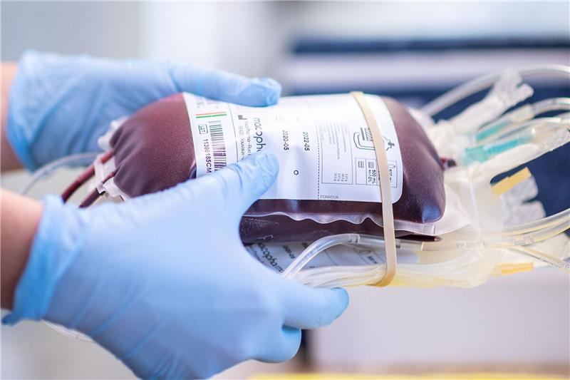 Zur Blutspende nach Wiepenkathen Eine Mitarbeiterin eines Blutspendezentrums hält eine Blutkonserve in den Händen.