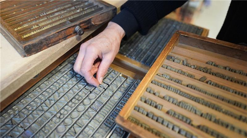 Älteste Buchbinderei gibt gedruckten Schätzen neuen Glanz Eine Mitarbeiterin hält in der Werkstatt der Buchbinderei Fritz Castagne Heißprägeschriften in der Hand.