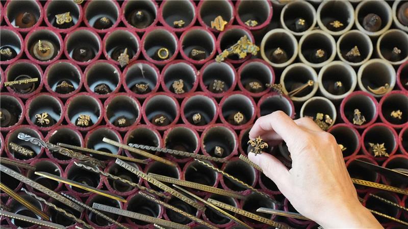 Älteste Buchbinderei gibt gedruckten Schätzen neuen Glanz Eine Mitarbeiterin zieht in der Werkstatt der Buchbinderei Fritz Castagne einen Vergoldestempel aus einem Regal.