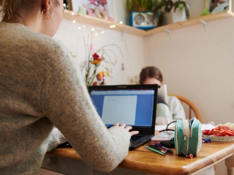 Mehrheit will auch nach Corona im Homeoffice arbeiten Eine Mutter arbeitet am Küchentisch während ihre Tochter gegenüber in ein Tablet guckt. Foto: Annette Riedl/dpa