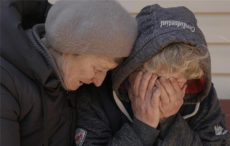 Gräuel in Butscha - wieviel Krieg zeigen deutsche Medien? Eine Nachbarin tröstet Natalja, deren Ehemann und Neffe von russischen Streitkräften getötet wurden, während sie in ihrem Garten weint. Die Menschen von Butscha haben furchtbare Gräuel erlebt und gesehen. Deutsche Medien zeigen vieles davon. Foto: Vadim Ghirda/AP/dpa