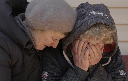 Eine Nachbarin tröstet Natalja, deren Ehemann und Neffe von russischen Streitkräften getötet wurden, während sie in ihrem Garten weint. Die Menschen von Butscha haben furchtbare Gräuel erlebt und gesehen. Deutsche Medien zeigen vieles davon. Foto: Vadim Ghirda/AP/dpa