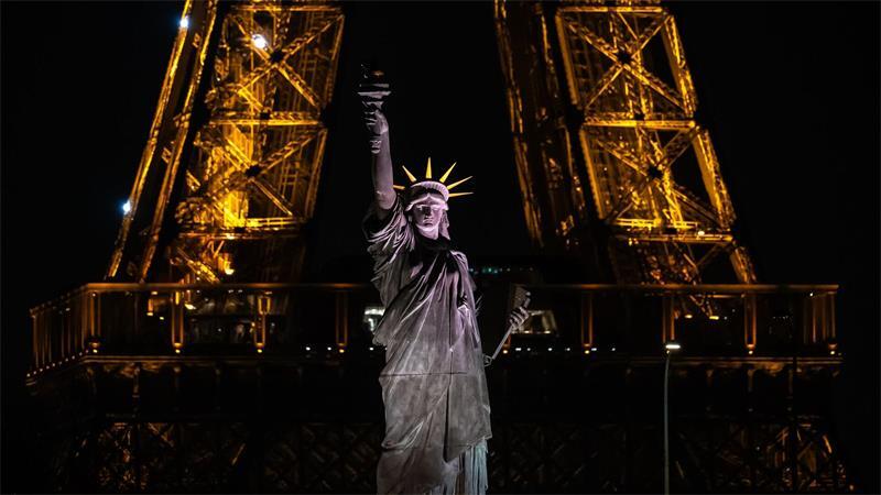 Eine Nachbildung der Freiheitsstatue steht vor dem Eiffelturm in Paris.