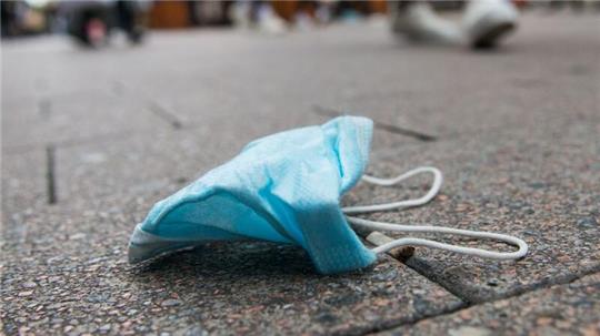 Eine OP-Maske liegt in der Hamburger Innenstadt auf dem Boden.