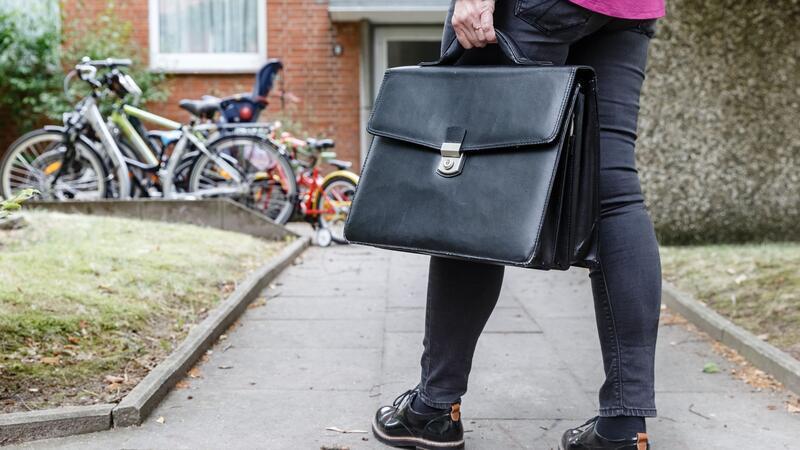 1002 Wohnungen in Hamburg zwangsgeräumt Eine Obergerichtsvollzieherin geht mit ihrer Aktentasche zu einer Wohnung.