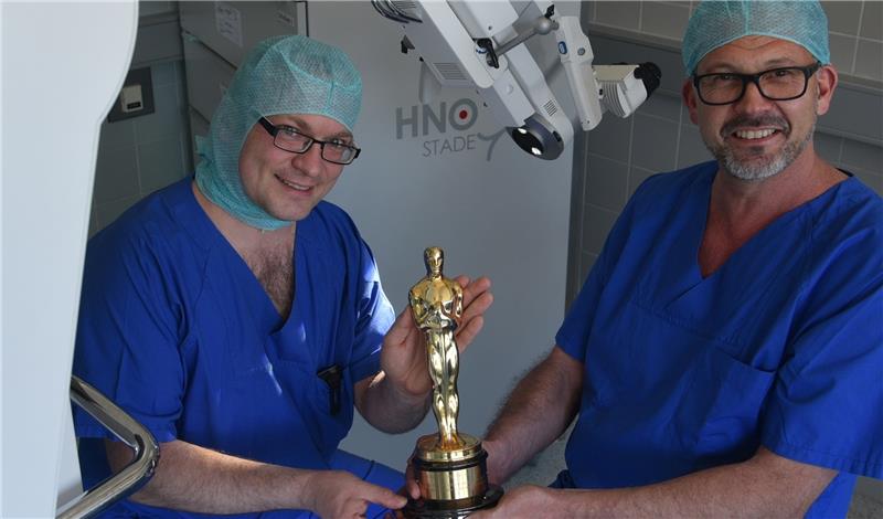 Eine Oscar-Statue in Operationssaal 8 : Der leitende Oberarzt Dr. Stefan Koppatz (links) und sein Chefarzt Professor Dr. Randolf Riemann von der Klinik für Hals-, Nasen- und Ohrenheilkunde in Stade präsentieren die Trophäe und das 3-D-Mikro