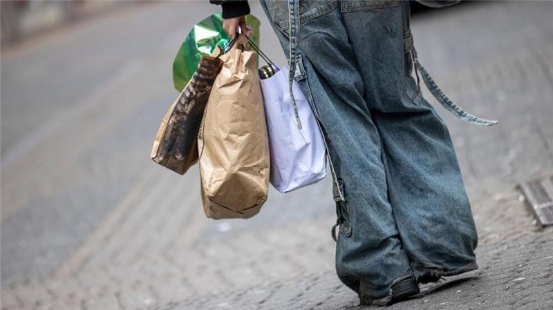 Kauflaune der Verbraucher bleibt gedämpft Eine Passantin geht mit Tragetaschen durch eine Einkaufstraße in Köln.