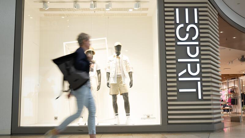 Eine Passantin geht vor einer Filiale des Modekonzerns Esprit entlang. Esprit schließt alle Filialen in Deutschland.
