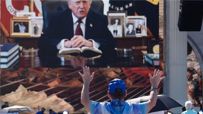 Eine Person betet, während eine aufgezeichnete Videobotschaft von US-Präsident Donald Trump abgespielt wird.