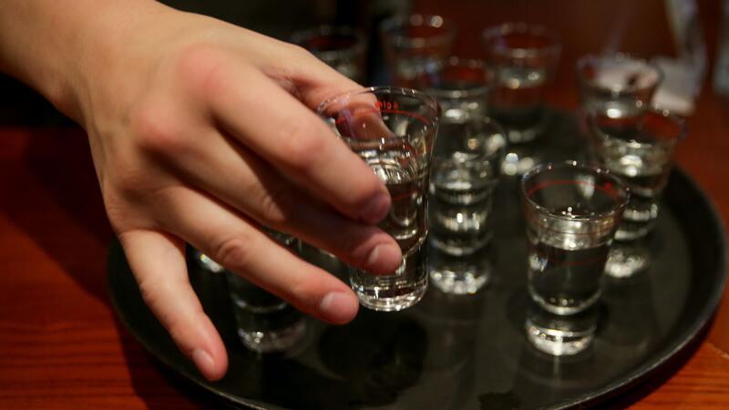 WHO fordert höhere Steuern auf Alkohol Eine Person greift nach einem gefüllten Schnapsglas. Mehr als zehn Millionen Menschen sterben laut der Weltgesundheitsorganisation (WHO) jedes Jahr durch Alkoholkonsum oder ungesunde Ernährung.