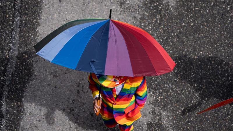Eine Person in einem Regenbogenanzug nimmt an der Vancouver Pride Parade teil.
