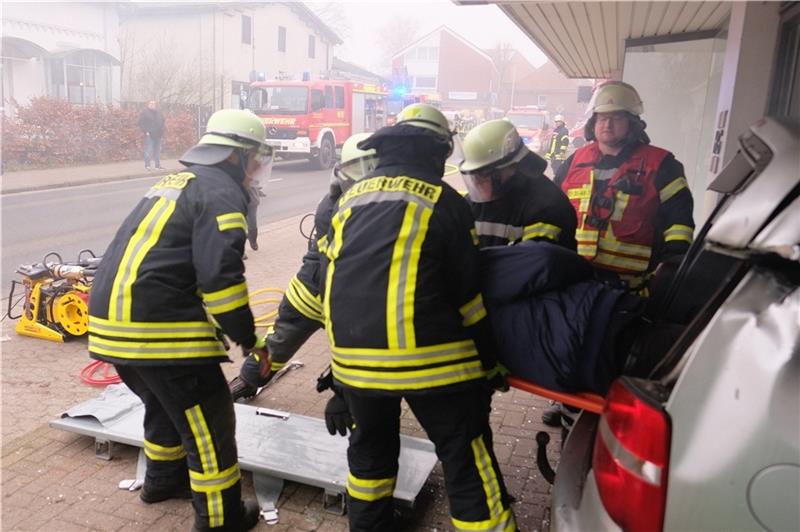 Eine Person wird aus einem Unfall-Auto gerettet, das in ein Schaufenster des Modehauses Heller-Gerken gefahren war. Foto: Hillyer-Funke