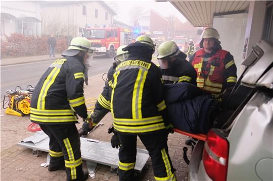 Eine Person wird aus einem Unfall-Auto gerettet, das in ein Schaufenster des Modehauses Heller-Gerken gefahren war. Foto: Hillyer-Funke