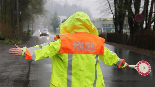 Eine Polizeibeamtin stoppt ein Fahrzeug bei einer Geschwindigkeitskontrolle. (Symbolbild)
