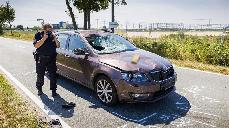 Eine Polizistin dokumentiert an einer Unfallstelle auf der K122 bei Lehrte in der Region Hannover Spuren.
