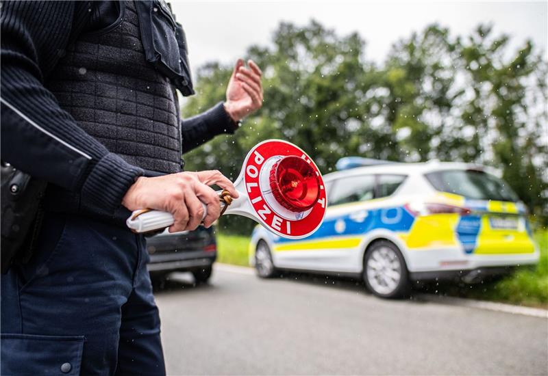Großkontrolle auf der A7: Mehr als die Hälfte der Fahrzeuge fällt durch Eine Polizistin hält eine Winkerkelle in der Hand.
