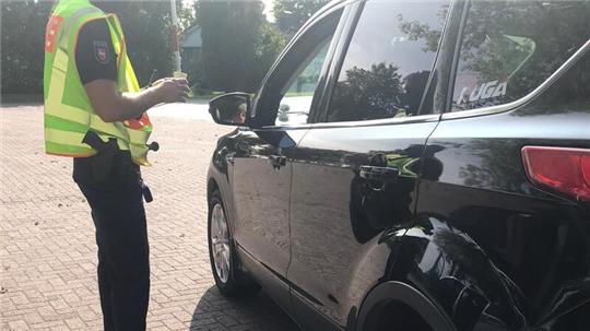 Eine Polizistin hält eine Winkerkelle in der Hand (Symbolbild).