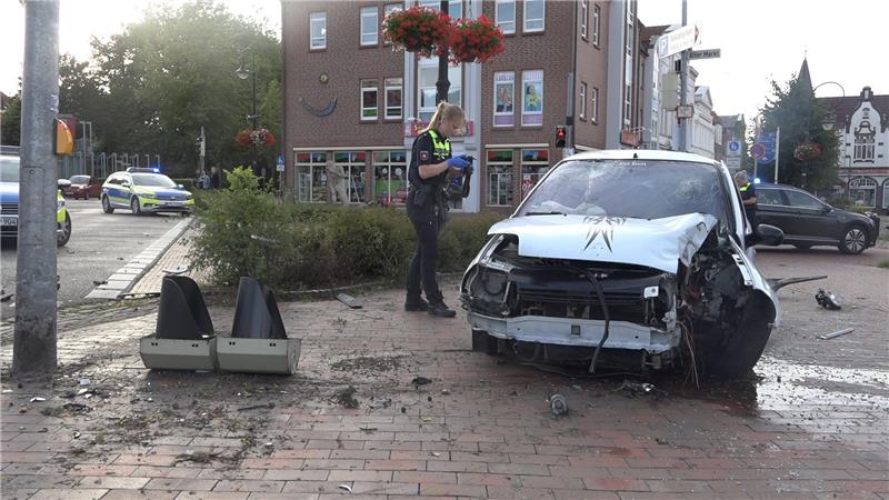 BMW-Fahrer gefährdet Menschenleben – Versteck bei Großfamilie Eine Polizistin untersucht das Wrack eines Pkw. Der Autofahrer war auf der Flucht vor der Polizei bei einem Unfall verletzt worden. Foto: Steve Hamann/Nord-West-Media TV/dpa