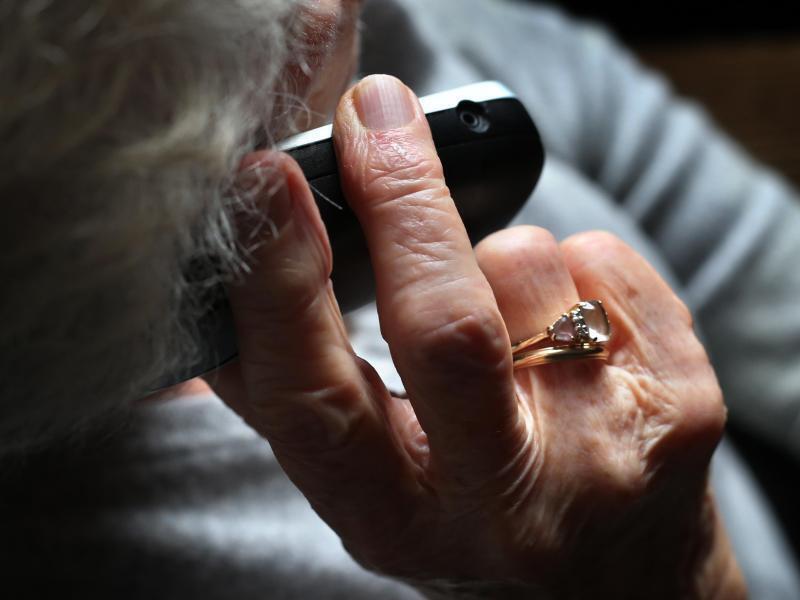 Eine Rentnerin hält ein Telefon in der Hand. Foto: Karl-Josef Hildenbrand/dpa/Symbolbild