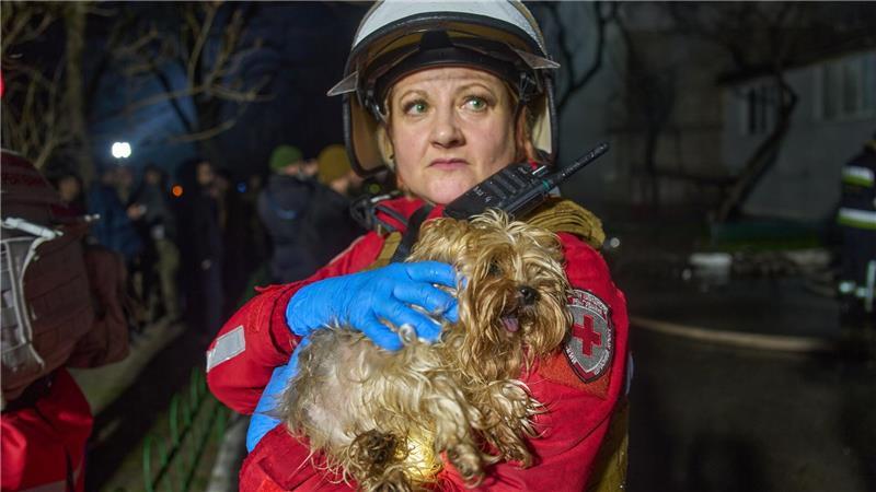 Eine Retterin hält einen geretteten Hund nach dem Einschlag einer russischen Rakete in ein mehrstöckiges Wohnhaus außerhalb von Kiew.
