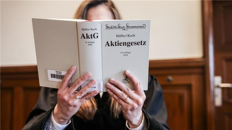 Recht einfach? Warum Juristendeutsch oft unverständlich ist Eine Richterin liest im Gerichtssaal im Aktiengesetz (AktG, gestellte Szene).