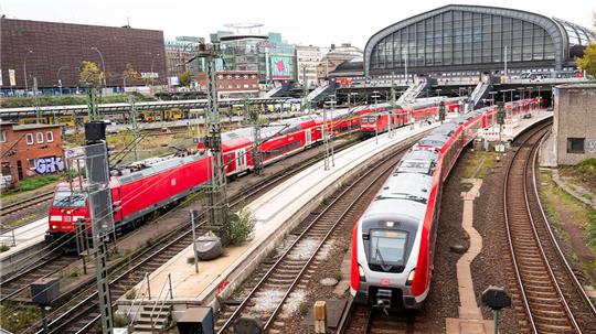 Eine S-Bahn fährt aus dem Hauptbahnhof aus. Daneben stehen zwei Regionalzüge der Deutschen Bahn. Foto: Daniel Bockwoldt/dpa