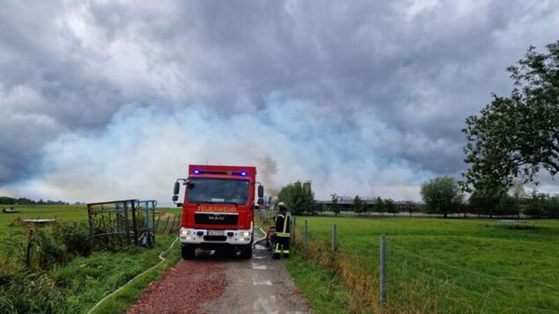 Eine Scheune im Köstersweg steht in Flammen, während dichte Rauchwolken die Umgebung verdunkeln.