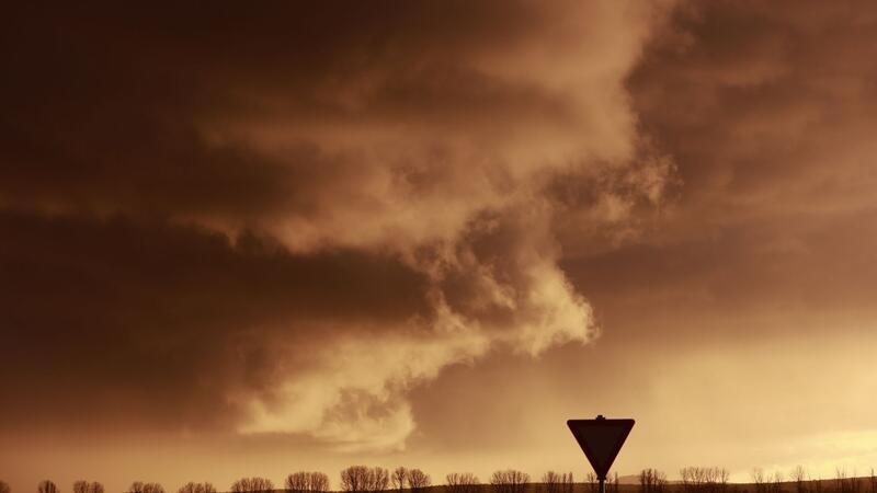 Eine Schlechtwetterfront zieht bei tief stehender Sonne über den Harz hinweg.