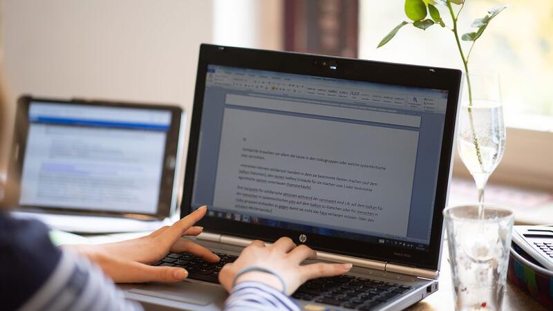 Pilotprojekt: Voll ausgestattete digitale Schulen Eine Schülerin erledigt Schulaufgaben an einem Laptop.