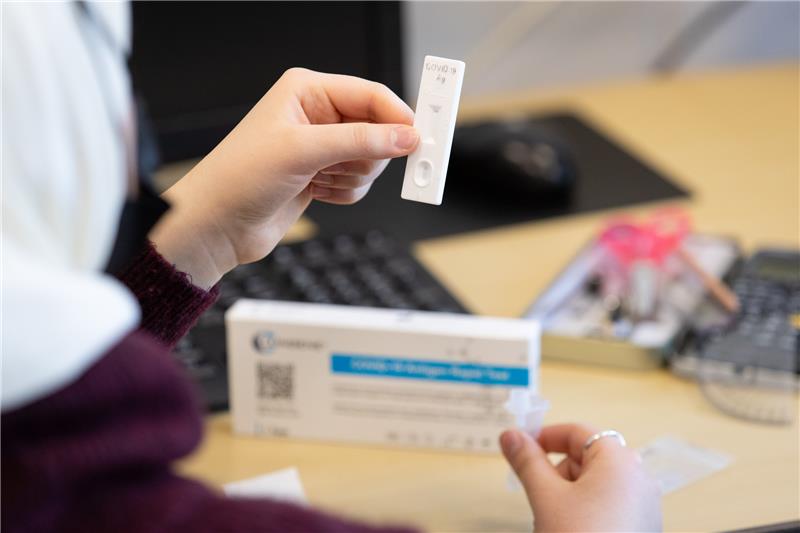 Eine Schülerin hält einen Teststreifen aus einem Corona-Antigen-Schnelltest. Foto: Friso Gentsch/dpa