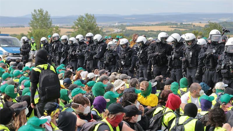 Eine Sitzblockade auf der Autobahn 71 - Polizisten umringen die Demonstranten.