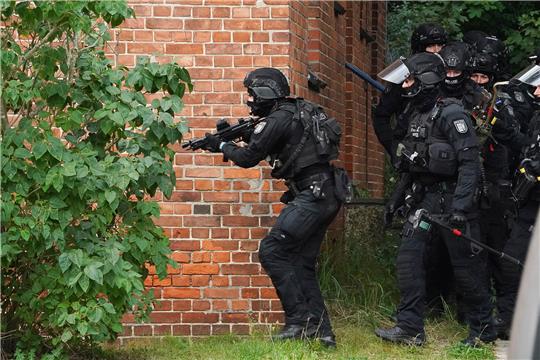 Eine Sondereinheit der Polizei durchsucht im Stadtteil Holtenau auf dem Gelände des ehemaligen Marinefliegergeschwaders 5 während einer Suchaktion nach einer 29-jährigen Frau ein Gebäude. Foto: Marcus Brandt/dpa