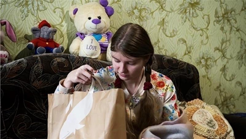 Eine Spendenempfängerin in der Ukraine packt eine der Tüten mit Lebensmitteln aus Dollern aus. Foto: Initiative „You are not alone“