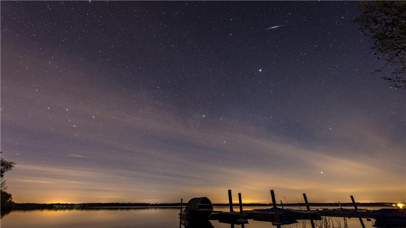 Eine Sternschnuppe der Lyriden ist am Nachthimmel über dem Spremberger Stausee in Brandenburg zu sehen.