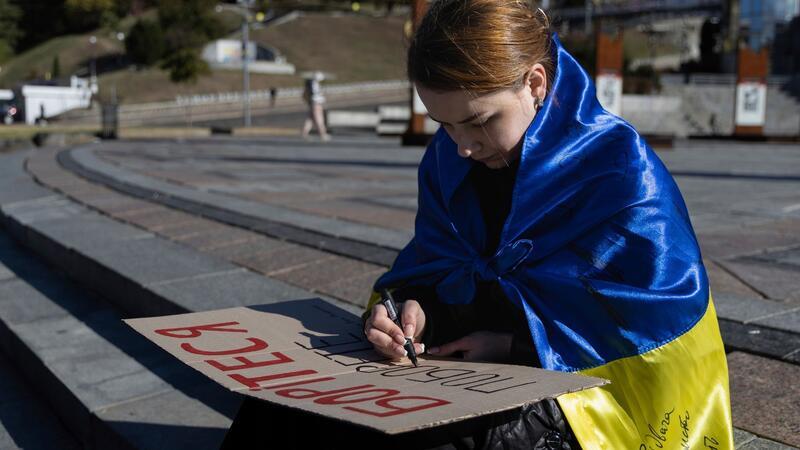 Krieg gegen die Ukraine: So ist die Lage Eine Studentin in Kiew schreibt die ersten Worte des ukrainischen Gedichts „Kämpfe weiter - du wirst siegen“ von Taras Schewtschenko auf ein Plakat.Fotograf