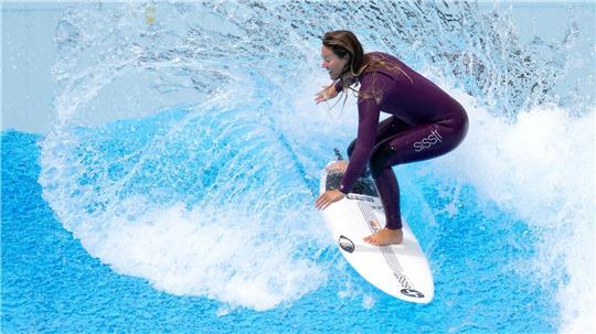 Eine Surferin reitet eine künstlich erzeugte Welle - wie es in dem geplanten Surfpark in Stade mal möglich sein soll.