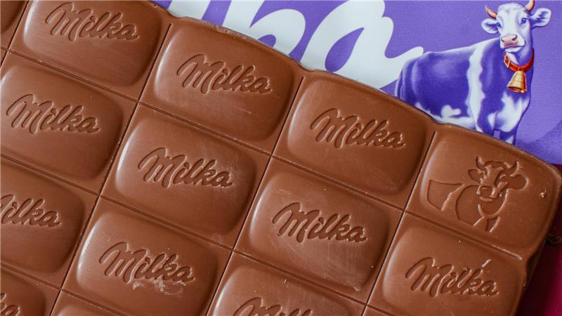 Eine Tafel Alpenmilch-Schokolade von Milka liegt auf einem Tisch.