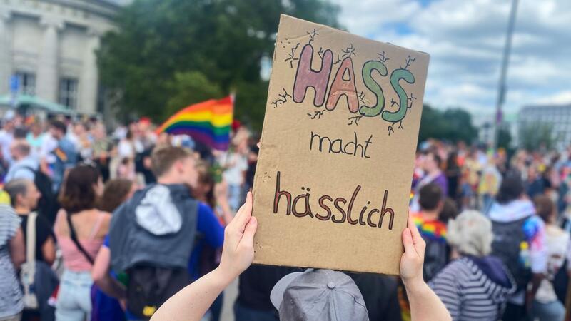 Eine Teilnehmerin an der letztjährigen CSD-Parade hält ein Schild mit der Aufschrift „Hass macht hässlich“ hoch.