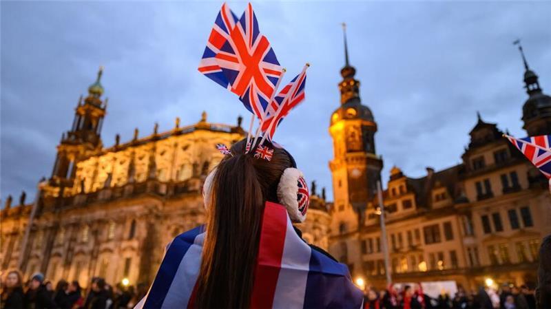 Eine Teilnehmerin des Challenger-Wettbewerbs im Synchroneiskunstlaufen aus Großbritannien steht am Abend in der Dresdner Altstadt.