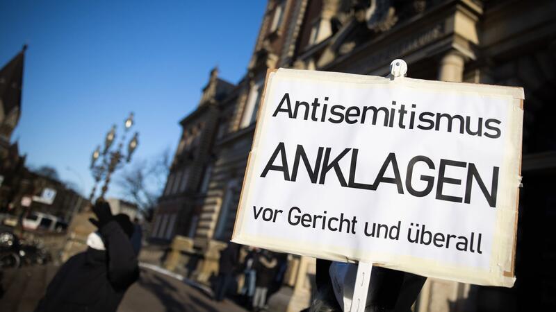 Zahl der antisemitischen Vorfälle in SH stark gestiegen Eine Teilnehmerin einer Kundgebung hält ein Schild mit dem Text „Antisemitismus Anklagen vor Gericht und überall“.
