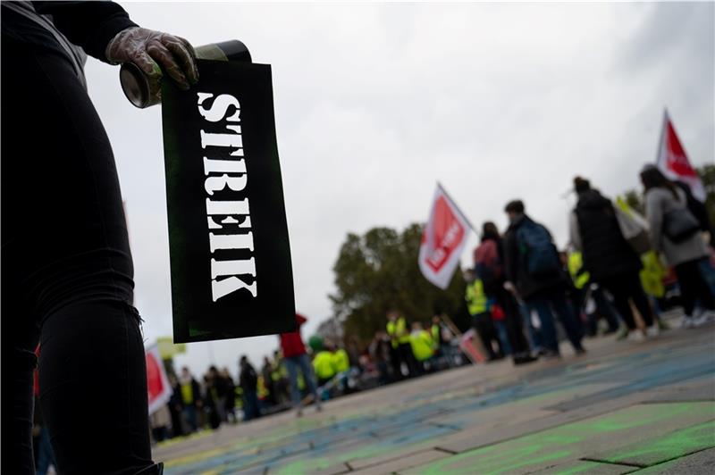 Eine Teilnehmerin hält während einer Demonstration eine Schablone für Kreidespray in der Hand, auf der „Streik“ steht. Foto: Sebastian Gollnow/dpa