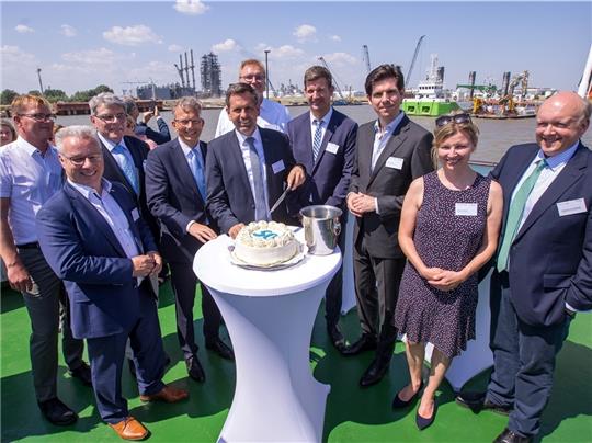 Eine Torte zum 50. (von links): Knut Kokkelink (NPorts), Stephan Engel (Dow), Volker Richter (AOS), Holger Banik (NPorts), Minister Olaf Lies, Marcus Schlichting (Seehafen ), Volker Weiß (NPorts), Daniel Richter (Buss), Alexandra Brandt (NP